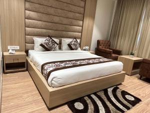 a bedroom with a large bed and a chair at RRV Hotel in Amritsar