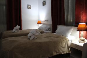 dos animales de peluche sentados en una cama en una habitación de hotel en Canawati Apartment, en Bethlehem