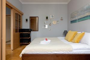 a bedroom with a large white bed with yellow pillows at Grójecka Stara Ochota Apartment in Warsaw