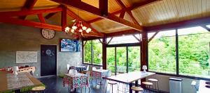 a dining room with tables and chairs and windows at Résidence LE11B in Uzerche