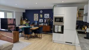 a kitchen and living room with a table and a refrigerator at Brand new large flat by the sea with free parking in Plymouth