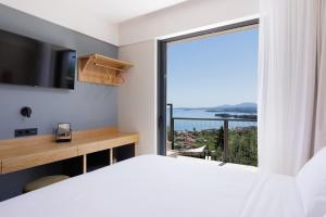 a bedroom with a large window with a view of the ocean at Greenstone Villas Corfu - Luxury Sea View Villas in Pyrgi