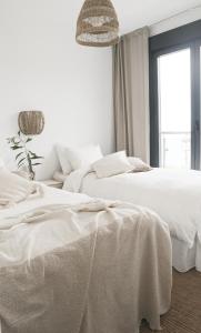 two white beds in a white bedroom with a window at Balcon Del Mar Nerja in Nerja +12 photos