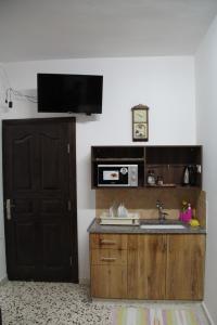 a kitchen with a sink and a microwave at Canawati Apartment in Bethlehem