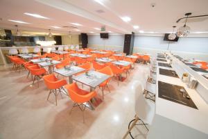 uma sala de jantar com mesas e cadeiras laranja em Intercity Campina Grande Citymix em Campina Grande