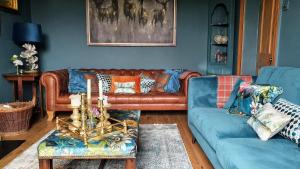 sala de estar con sofá de cuero marrón y paredes azules en Rock View, Wensleydale en Leyburn