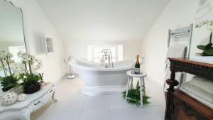 a white bathroom with a tub and a sink at Rock View, Wensleydale in Leyburn
