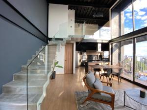 a staircase in a living room with a table and chairs at Loft Doble Altura, Colonia Americana @serra in Guadalajara