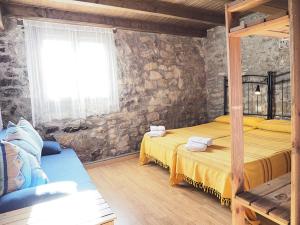 a bedroom with two beds and a stone wall at Casa Tomaso - Turismo Rural in Reperos