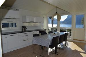 a kitchen and dining room with a table and chairs at Hytte i Raftsundet in Digermulen