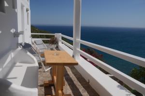 a table and chairs on a balcony overlooking the ocean at Agia Kyriaki Studios in Agia Kiriaki Beach