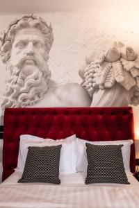Eine Statue eines Mannes ist über einem Bett in der Unterkunft Relais Manzoni in Rom