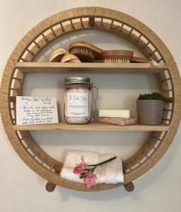 uma prateleira redonda de madeira com um frasco e outros itens nela em The Pink Cottage (upstairs suite) & Secret Garden em Whitehead