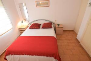 ein Schlafzimmer mit einem roten und weißen Bett mit zwei roten Kissen in der Unterkunft 394-Duplex moderno cerca playa y en pleno centro in Empuriabrava