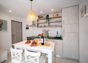 uma cozinha branca com uma mesa e cadeiras brancas em New cozy apartment - center of old town Omiš em Omiš