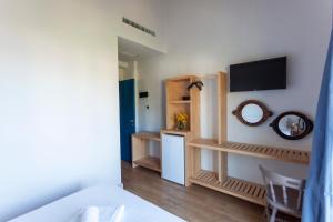 een kamer met een bed en een televisie aan de muur bij Toni Retzo Rooms in Himare