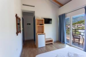 a bedroom with a bed and a balcony with a view at Toni Retzo Rooms in Himare