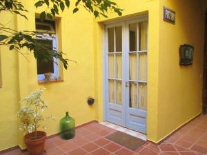 una casa amarilla con una puerta y un jarrón al lado en La Querencia de Buenos Aires en Buenos Aires