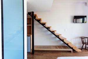 een trap in een kamer met witte muren en houten vloeren bij Toni Retzo Rooms in Himare