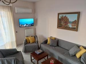 a living room with a couch and a tv at Sea view,big and comfortable appartment in Voula in Athens