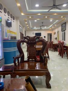 河江的住宿－Khách Sạn Nhà Hàng Lương Gia，配有桌椅的房间的木椅