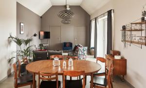 a living room with a wooden table and chairs at Gîte Les Ganades au cœur des pépinières in Brunehaut