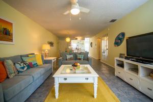 a living room with a couch and a tv at Beach Potato - 3404 Gulf Dr 5 in Holmes Beach