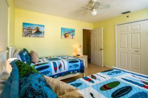 a bedroom with two beds and a ceiling fan at Beach Potato - 3404 Gulf Dr 5 in Holmes Beach +19 photos