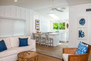 un soggiorno e una cucina con un divano e un tavolo di Island Time: AMI North End, Pool, Close to City Pier & Pine Ave by Anna Maria Life Vacation Rentals ad Anna Maria