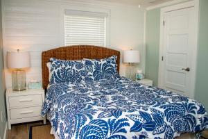un letto con piumone blu e bianco e 2 lampade di Island Time: AMI North End, Pool, Close to City Pier & Pine Ave by Anna Maria Life Vacation Rentals ad Anna Maria Altre 28 foto