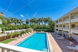 a swimming pool in the backyard of a house with palm trees at AMI Dreaming - 4200 Gulf 105 in Holmes Beach