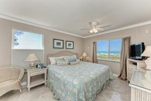 a bedroom with a bed and a tv and a window at AMI Dreaming - 4200 Gulf 105 in Holmes Beach