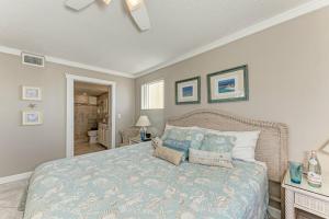 a bedroom with a bed with a blue comforter at AMI Dreaming - 4200 Gulf 105 in Holmes Beach +22 photos