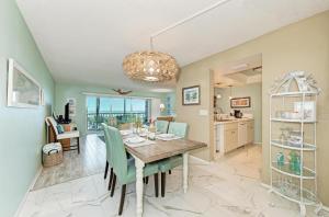 a dining room and kitchen with a table and chairs at Sunset Beach 102: Gulf Front, Stunning Views, On the Beach, Pool by Anna Maria Life Vacation Rentals in Holmes Beach