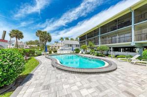 a swimming pool in front of a building at Sunset Beach 102: Gulf Front, Stunning Views, On the Beach, Pool by Anna Maria Life Vacation Rentals in Holmes Beach
