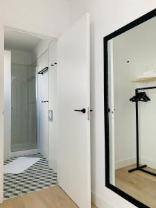 espejo en una habitación blanca con pasillo en Casa Miguel - Apartamento 4, en Sanlúcar de Barrameda