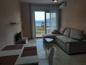 a living room with a couch and a view of the ocean at Antea Apartment 3 in Vlorë