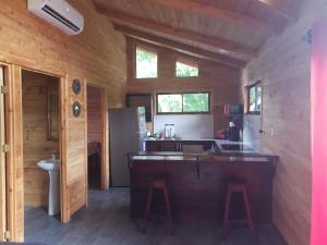 a kitchen with a large island in a log cabin at Cabaña Tio King in Uvita