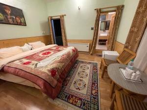 a bedroom with a bed and a table and a mirror at Hotel Ladakh Greens in Leh