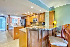 a kitchen with wooden cabinets and a counter top at Water View 506 in Clearwater Beach