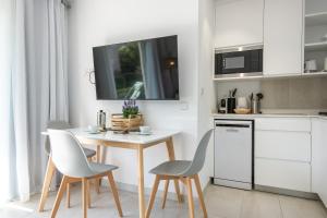 uma cozinha com uma pequena mesa e cadeiras numa cozinha em Sea apartment 1C with pool , 150 meters Canyamel Beach em Capdepera