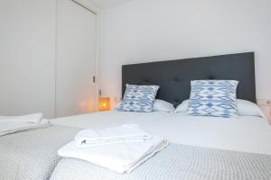um quarto com 2 camas com almofadas azuis e brancas em Sea apartment 1C with pool , 150 meters Canyamel Beach em Capdepera