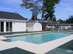 a swimming pool in front of a house at Thunderbird Inn of Mackinaw City in Mackinaw City