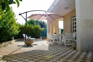 a patio with an umbrella and a table and chairs at Villa Giovanna in San Pietro in Bevagna