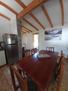 comedor con mesa de madera y nevera en Cabañas Golem - Con Piscina, en Guangualí