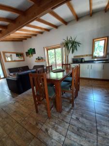 a kitchen and dining room with a wooden table and chairs at Cabañas Golem - Camino Termas de Chillán in Guangualí