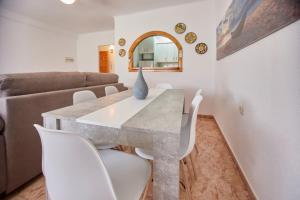 a dining room with a table and white chairs at Apartamento Luna Cabo de Gata in El Cabo de Gata