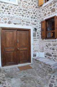 ミティムナにあるMolivos Towerの木製のドアと窓のある石造りの建物