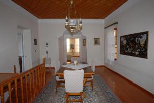 a dining room with a table and chairs and a chandelier at Molivos Tower in Mythimna