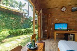 a room with a bed and a tv and a window at Dendi Resort Phu Quoc in Phu Quoc